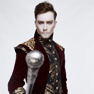 Man in steampunk aristocrat outfit with red velvet coat and gold embroidery holding a cane