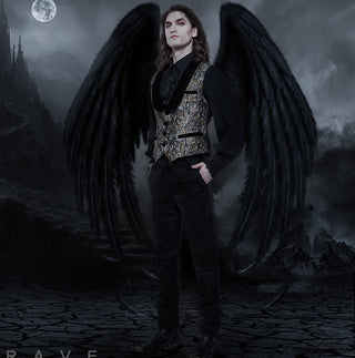 Gothic groom in brocade waistcoat with black angel wings, styled for an alternative dark fantasy wedding.
