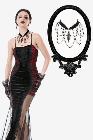 Woman wearing a black and red Gothic velvet dress with a layered black beaded choker featuring a red cross pendant, displayed with a close-up framed view on a white background.