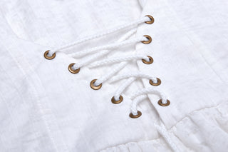 Close-up of white corset-style back lacing with bronze eyelets on gothic dress