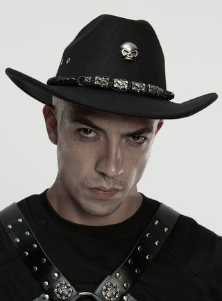 Man wearing punk rave ws-860 a black Gothic cowboy hat with skull emblem and chain band, styled with a black harness top on a white background.