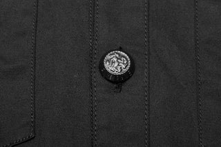 Close-up of black enamel button on men’s gothic shirt