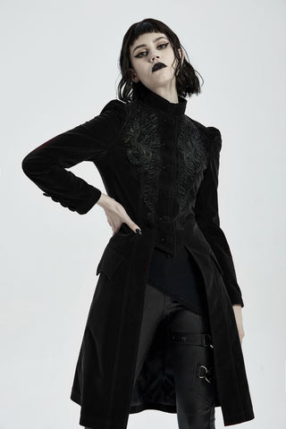 Model posing in punk rave wy-1306 a long black Gothic velvet coat with ornate embroidery and corset back, photographed on a white background.