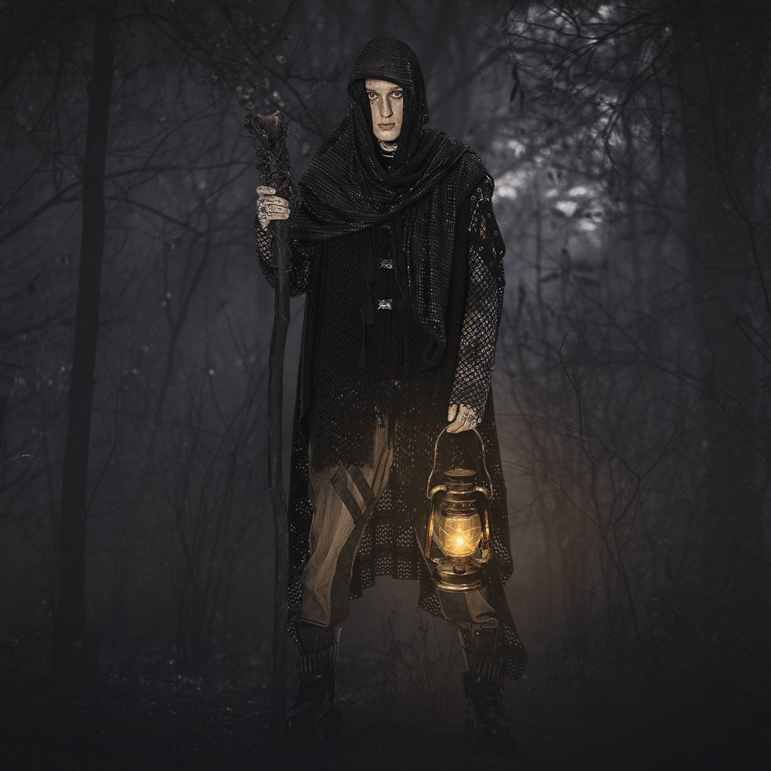Gothic man in hooded cloak holding a lantern in a dark forest, Halloween costume aesthetic