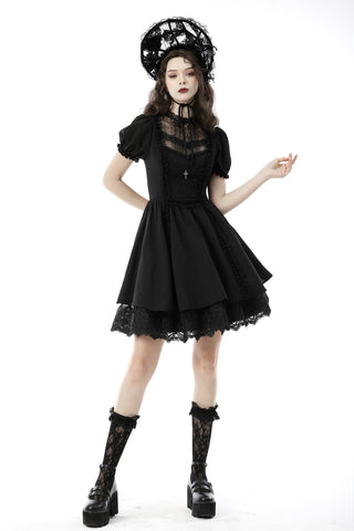 A model wearing a black gothic-style short dress with sheer lace details, a matching black lace headpiece, and black lace knee-high socks with platform boots, posed against a solid white background.