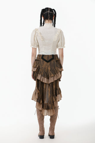 Person wearing a white blouse and brown tiered skirt on a white background