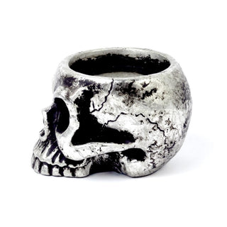 Side view of an antique silver skull tea light holder showing the cracked resin finish