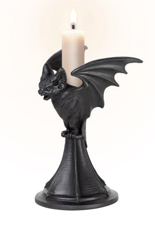 Black bat taper candle holder with a lit white candle on a white background