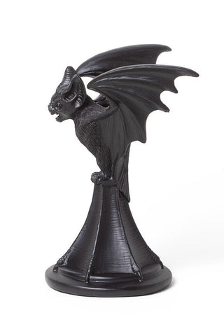 Side view of a black bat taper candle holder with raised wings on a white background