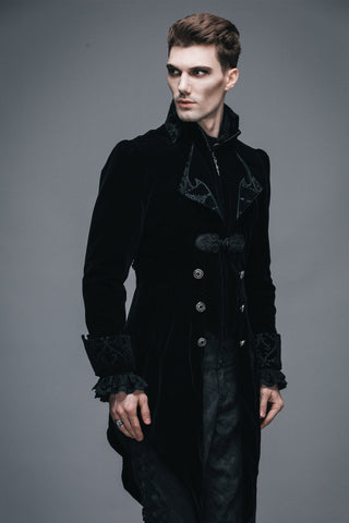 Angled view of man in black Gothic velvet tailcoat with ornate lapels and fitted cuffs