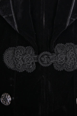 Close-up of black Gothic velvet tailcoat showing ornate front knot closure and silver buttons