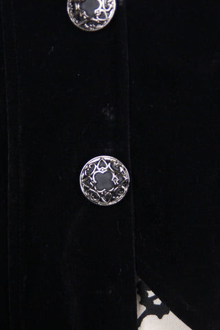 Close-up of ornate silver button on black Gothic velvet tailcoat