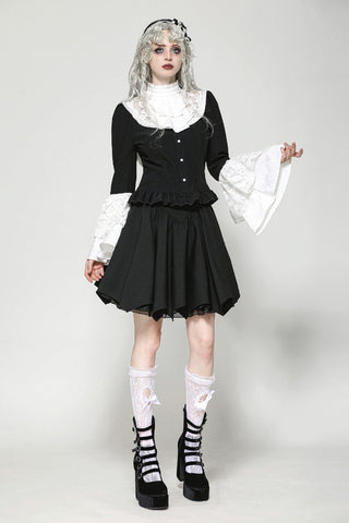 Front walking pose of model in black and white Victorian-style blouse and skirt
