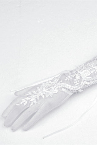 Close-up of white lace bridal glove showing floral embroidery and mesh detail