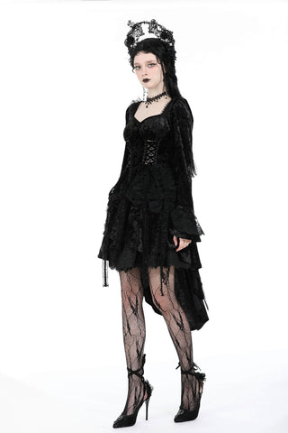 Model in black Gothic dress with corset bodice, layered lace skirt, bell sleeves, and ornate lace headpiece – standing against a white background.