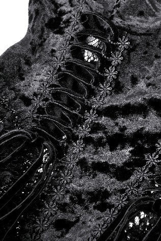Close-up of black velvet fabric with floral lace trim and corset-style lacing.