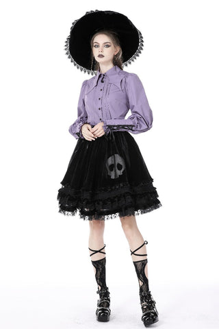 Model wearing light violet witchy shirt with puff sleeves and bat collar, styled with black skirt and hat