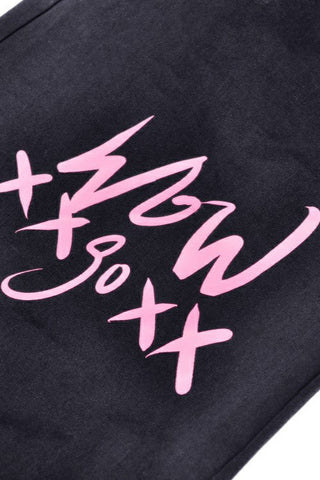 Pink graffiti-style print on black fabric with abstract symbols and strokes