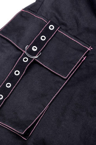 Close-up of grommet strap and flap pocket with pink contrast stitching on black fabric