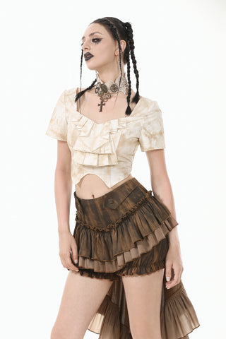 Model in Steampunk-style beige blouse and tiered brown skirt, posing with braids and statement necklace on white background.