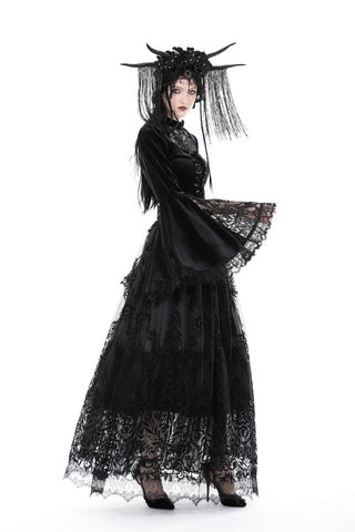 Person wearing a black lace top, showcasing wide flared sleeves and lace detailing, styled with a horned headpiece and long black skirt against a white background.