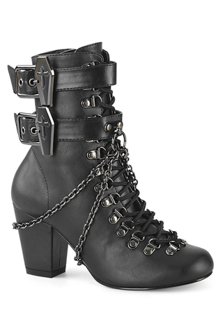 Black matte ankle boot with coffin-shaped metal buckles, lace-up front, and decorative chains on a white background.