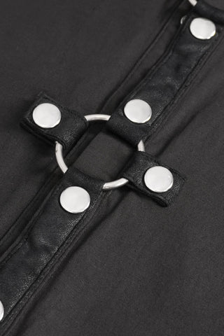 Close-up of black faux leather straps with silver snap buttons and a central metal ring on a black cotton base.