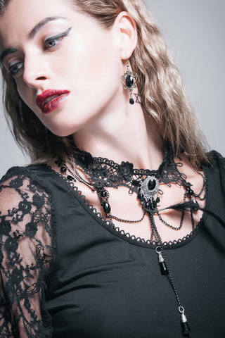 Model wearing the Mourning Belle black lace choker with draped chains, an oval black centrepiece and long pendant drops.