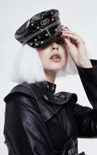 Close-up of black patent studded chain cap with spikes worn with PU leather coat and mesh panel top