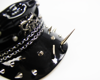 Close-up of black patent studded chain cap with metal spikes detail