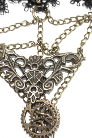 Close-up of the Devil Fashion AS057 hand harness centerpiece showing ornate antique brass filigree and gear detail with layered chain links.