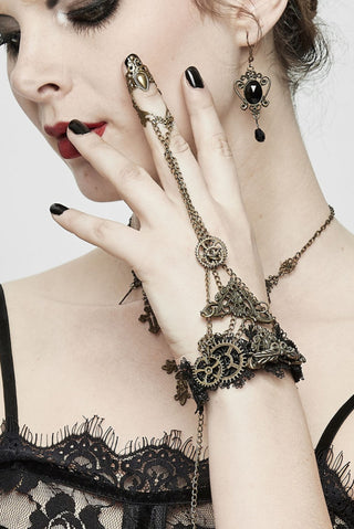 Close-up of Devil Fashion AS057 Steampunk bracelet ring chain featuring detailed brass gears, black lace cuff, and finger chain links on model’s hand.