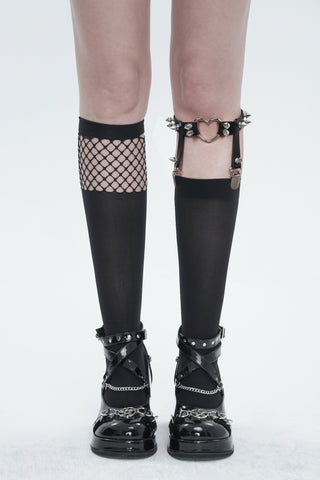 Asymmetrical black tights with one fishnet leg and one opaque leg, featuring a heart garter with spikes, worn with black platform shoes, on a white background.