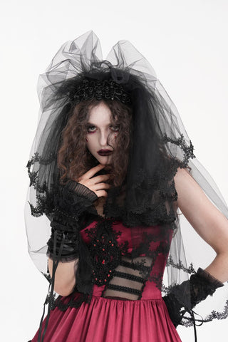 Model wearing a black gothic ghost bride veil with lace trim and skull crown