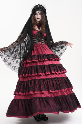 Model wearing a layered red and black Gothic dress with lace veil and bead-trimmed headdress, styled in a dark romantic bridal look.