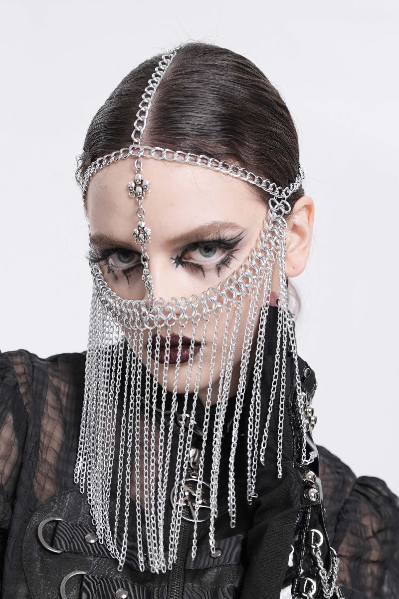 Model wearing a silver chain veil headpiece with a vertical skull pendant drop and layered facial drape.