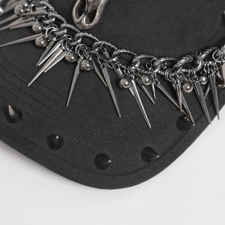 Close-up of the front brim on a black cap with chain trim and hanging metal spike details.