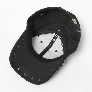 Inside view of black cap showing eyelets, interior band, and metal spike hardware anchors.