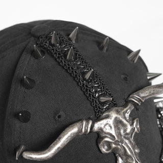 Close-up of black cap with spike studs and horned skull emblem on the crown.