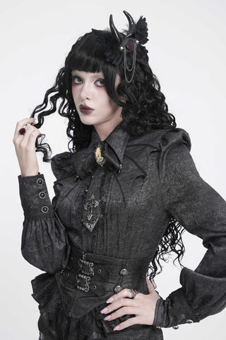 Model wearing a Devil Fashion evil eye hair clip with black feathered wings, curved horns and draped silver chains.