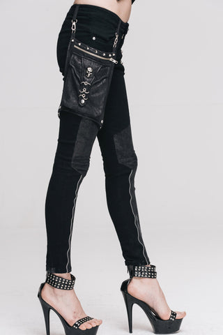 Devil Fashion PT01801 women’s black skinny trousers with detachable pocket bag, zipper details, and stud accents, modeled against a white background.