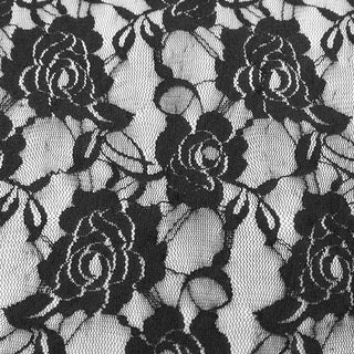 Close-up of Devil Fashion PT050 Gothic pants fabric showing black rose lace pattern on sheer mesh background.