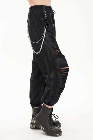 Devil Fashion PT174 black punk cargo pants side view, showing distressed slashes with mesh backing, detachable double chain, O-ring strap, elastic waistband, and cuffed ankle detail.