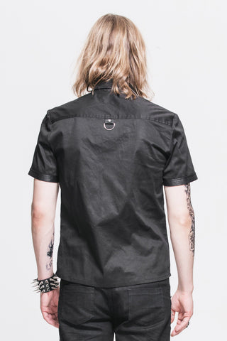 Man facing backward wearing a black short-sleeve shirt with faux leather accents and a metal ring detail on the upper back, against a white background.
