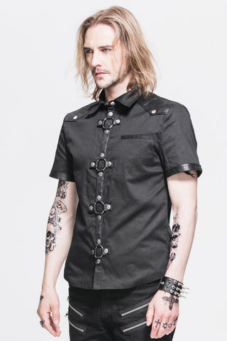 Man wearing a short-sleeve black cotton shirt with faux leather trims and front metal ring details, standing against a white background.