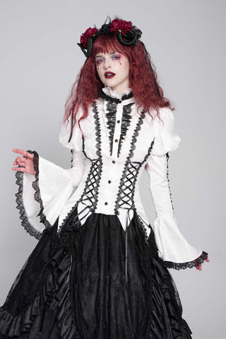 White Victorian gothic blouse with black lace trim, bell sleeves, lace-up waist detailing and pointed hem worn with a black layered skirt.