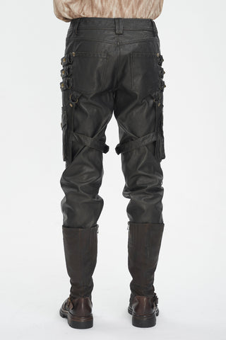 Back view of Devil Fashion PT24402 Steampunk pants in brown faux leather with brass studs, cargo pockets, and side straps, styled with tall brown boots.