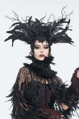 Black feather crown with branch accents worn with black feathered garment on a white background.