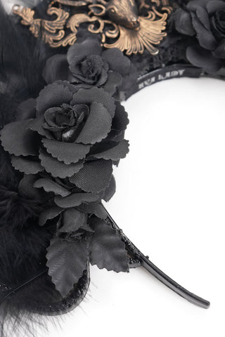 Close-up of black artificial roses, feathers, and part of the headband base on a Gothic-style headpiece, white background