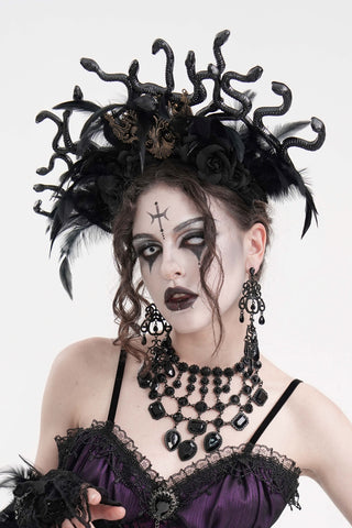 Model in Gothic Medusa headpiece with sculpted black snakes, dramatic dark makeup, and Victorian-style jewellery on a white background.